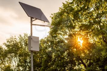 Solar panel and LED street light with natural background before sunset