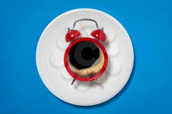Coffee break concept. Black coffee in retro alarm clock