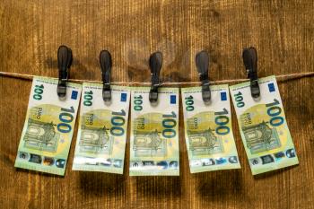 Money laundering concept with banknotes of hundred euros on the rope