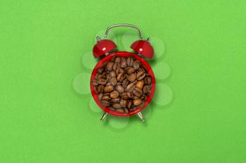 Morning coffee and alarm clock concept. Coffee beans on the  clock  face.