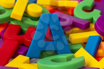 Blue letter A on the pile of colorful plastic letters 