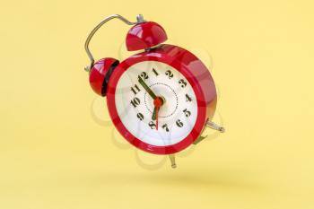 Falling alarm clock showing eight o'clock. Conceptual image.