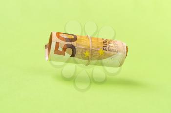 Roll of euro currency levitating over green background. Financial concept.