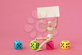 Wooden man sits on the dice and holding blank banner for your own text
