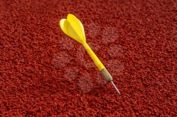 Yellow dart arrow on a running track in a stadium