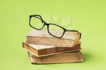 Wisdom and knowledge. Reading a books. Eyeglasses laid up on an old books.