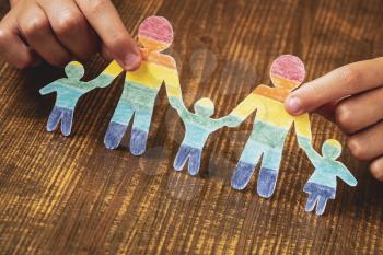 Child holding paper family in LGBT rainbow colors.LGBT rights. Equality of rights. Human rights.