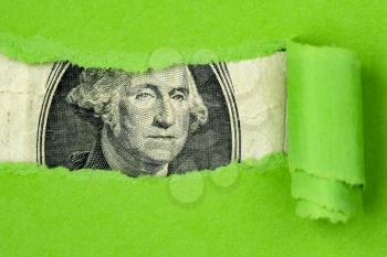 US currency macro peeking through torn green paper