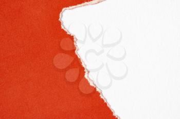 Red paper torn to reveal white paper background for copy-space