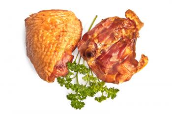 Two smoked chicken thighs, a sprig of green parsley isolated on white background