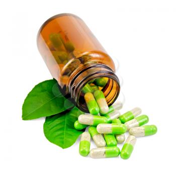 Green capsules in an open brown jar and on the table, two green leaf isolated on white background