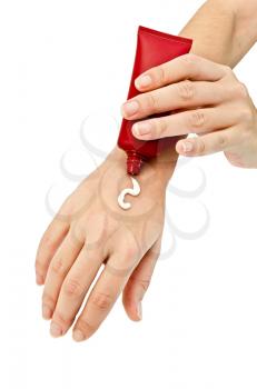 Cream in a red tube coated on hand of woman isolated on white background