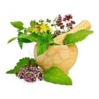 Sprigs of mint, lemon balm, oregano, tutsan, sage leaves in a wooden mortar and on the table isolated on white background