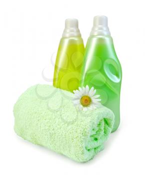 Two bottles of fabric softener yellow and green, green towel, camomile isolated on white background
