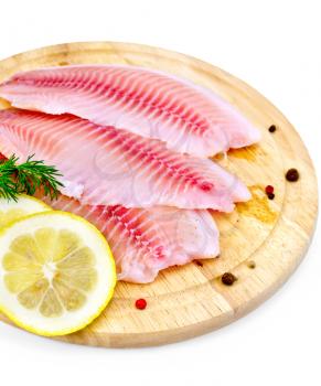 Tilapia fillets with dill, lemon slices, peppercorns on a wooden board isolated on white background