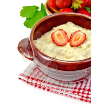 Oatmeal with strawberry in pottery on a napkin, strawberries with green leaf isolated on white background