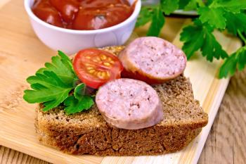 Fried pork sausage on a slice of bread with tomato and parsley, tomato sauce on a wooden boards background