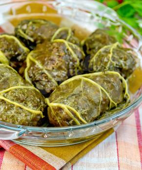 Stuffed cabbage with meat and rhubarb leaf in a glass pan on a background of a linen cloth