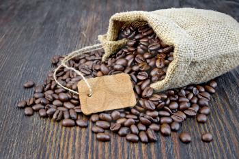 Bag of black coffee beans, tag on the background of a wooden board