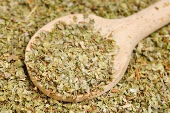 Dried marjoram spice  and wood spoon  as  food background
