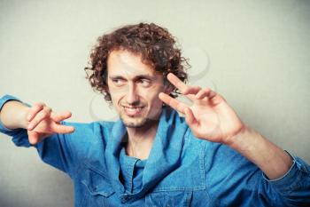 curly-haired man showing two fingers