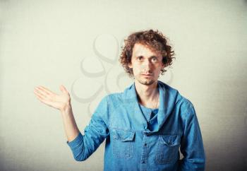 Curly man showing a space. On a gray background.
