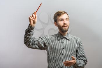 Young handsome man one hand with a pencil in. Gesture. On a gray background