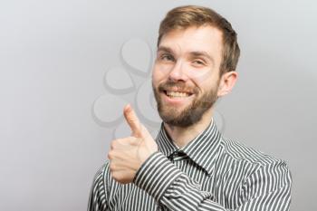 young casual man showing thumb up and smiling