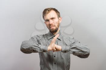 young man angry gesturing fist raised menacing threat studio portrait on isolated gray background