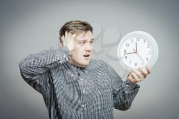 A man looking at the big clock. Gray background