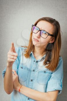 Closeup portrait shocked terrified business woman in glasses looking surprised full disbelief saw something pointing finger at camera  grey wall background. Negative emotion facial expression reaction