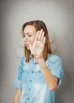 Closeup portrait of young annoyed woman with bad attitude, giving talk to hand gesture with palm outward, isolated on white background. Negative human emotion, facial expression feeling, body language