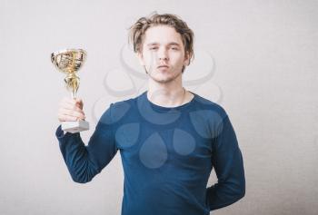 young man holding a prize cup and happy