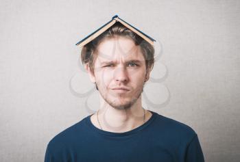Bored college student with a book on his head