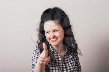 Closeup portrait of young, beautiful, excited, happy woman smiling, laughing, pointing finger towards you, camera gesture. Positive human emotion, attitude, reactions