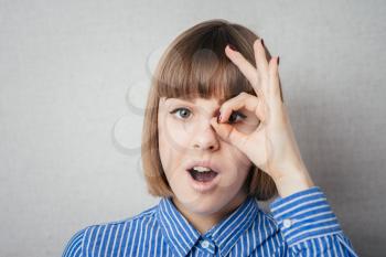 Woman with ok sign on eye