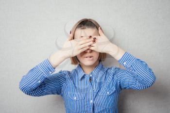 woman covering her eyes by hands over dark background