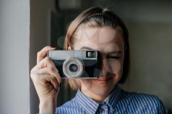 Portrait of a beautiful and attractive young woman holding a camera