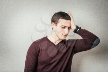 Depressed young business man holding his head
