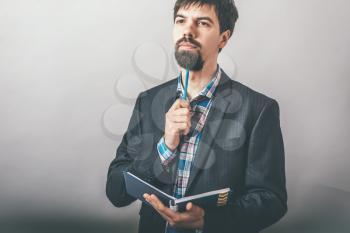Businessman thinking with a notebook and pencil