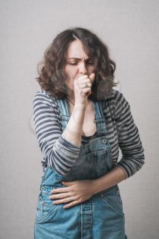 coughing girl dressed in overalls