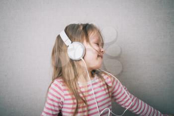 Beautiful cute happy little girl with headphones