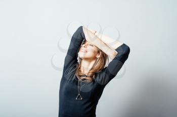 A woman wants to sleep, stretching. Gray background