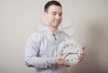 A man looking at the big clock. Gray background