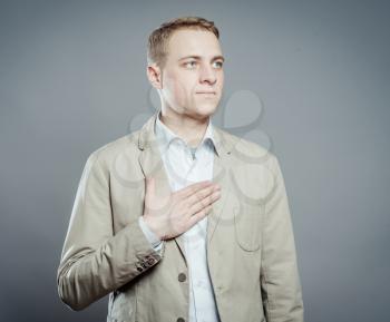 young man with chest pain standing at gray background