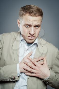 Businessman with hands on  his chest. hearts pain