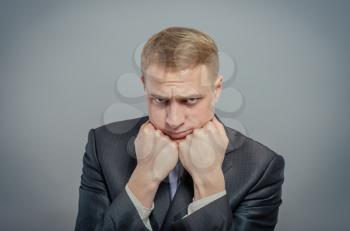 Young businessman thinking with his head on his fists