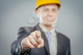 young  man in a yellow helmet pointing at someone gesture with finger