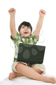 Happy little boy with laptop with moving apart his hands - indoors 
