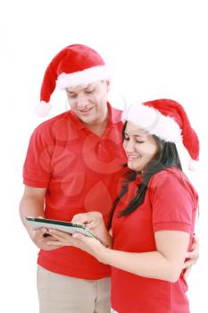 Happy Christmas couple looking a tablet computer. Isolated on white background. 